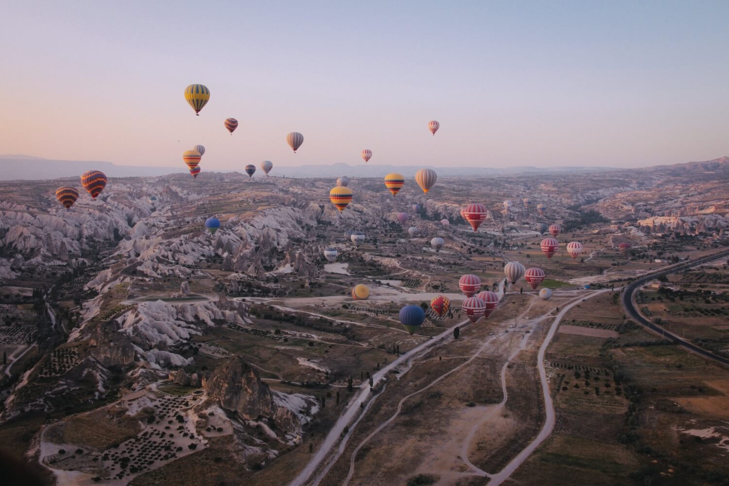Lot balonów nad malowniczym krajobrazem